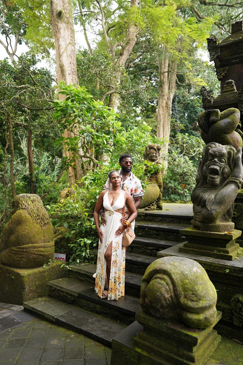 The couple among mossy statues in the forest